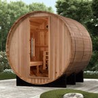 Wooden barrel-shaped sauna in an outdoor setting with trees and grass.
