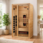 Wooden infrared sauna in a room with a plant and a couch.