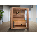 Wooden sauna with a modern interior design, featuring a plant and a view of water outside.