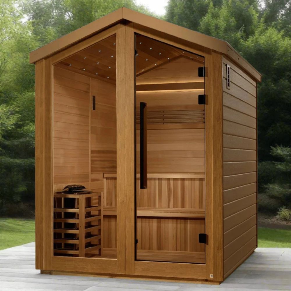 Wooden sauna with interior benches and shelves on a wooden deck with greenery in the background