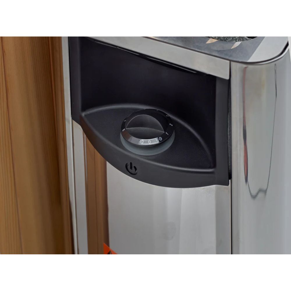 Close-up of a metallic appliance with a black component on a wooden surface.