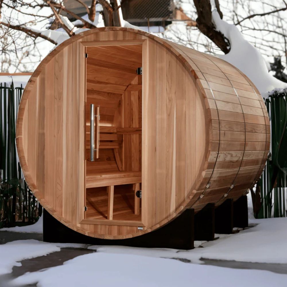 Wooden barrel-shaped sauna in a snowy outdoor setting