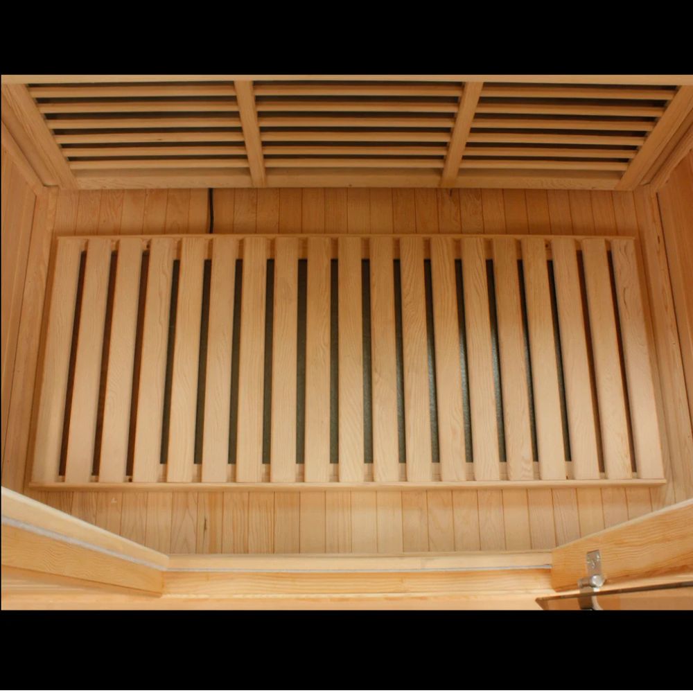 Wooden sauna interior with slatted ceiling and bench