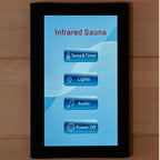 Touchscreen control panel for an infrared sauna on a wooden surface