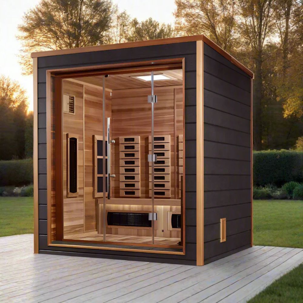 Outdoor sauna with wooden interior and black exterior on a wooden deck with trees in the background.