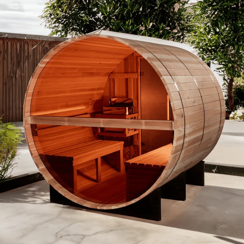 Wooden barrel-shaped outdoor structure with benches inside, set against a natural background.