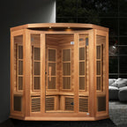 Wooden sauna cabin in a room with a dark tiled wall and gray sofa.