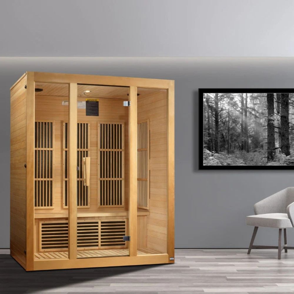 Wooden infrared sauna in a room with a gray wall and a framed picture of a forest.