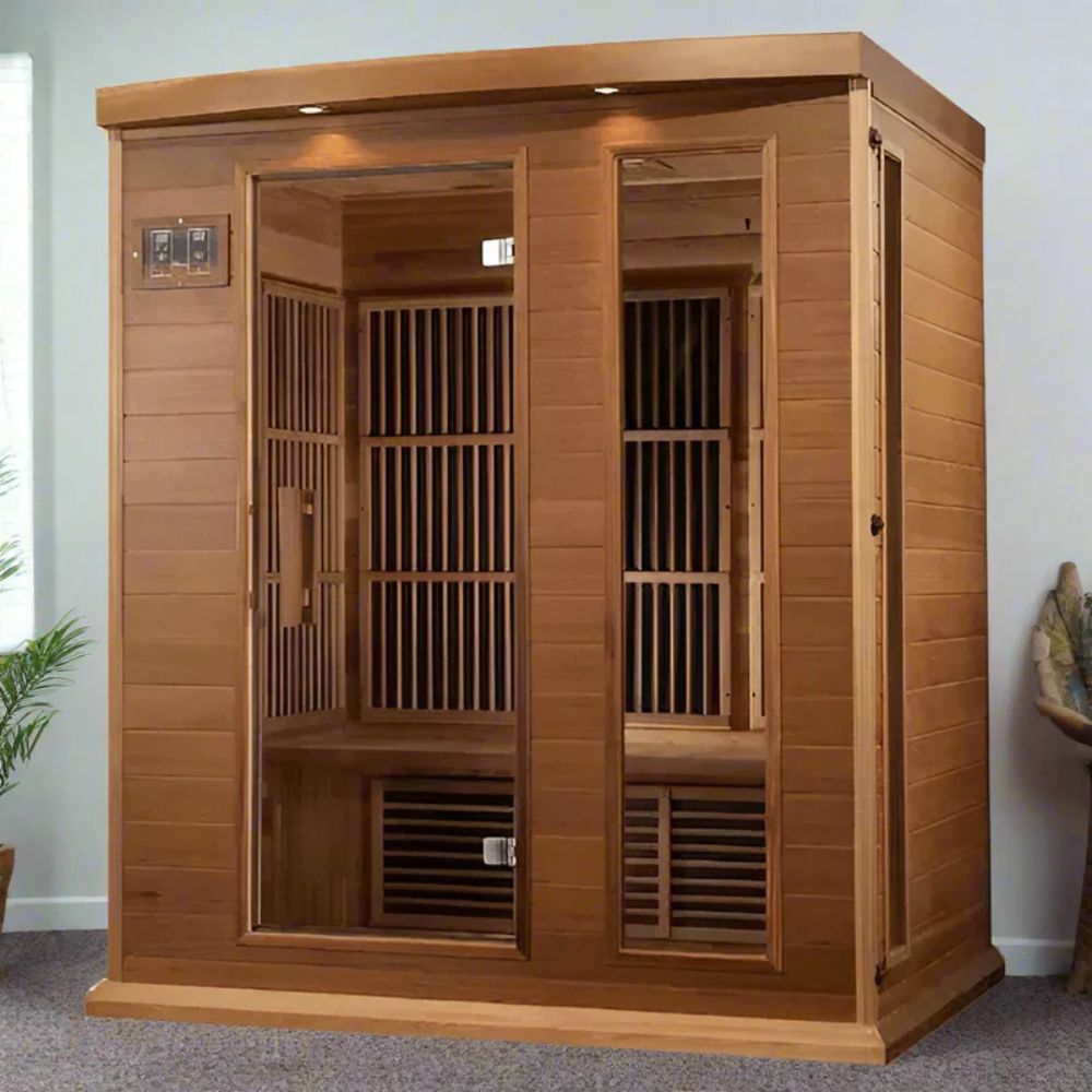Wooden infrared sauna in a room with a plant and decorative item on the wall.