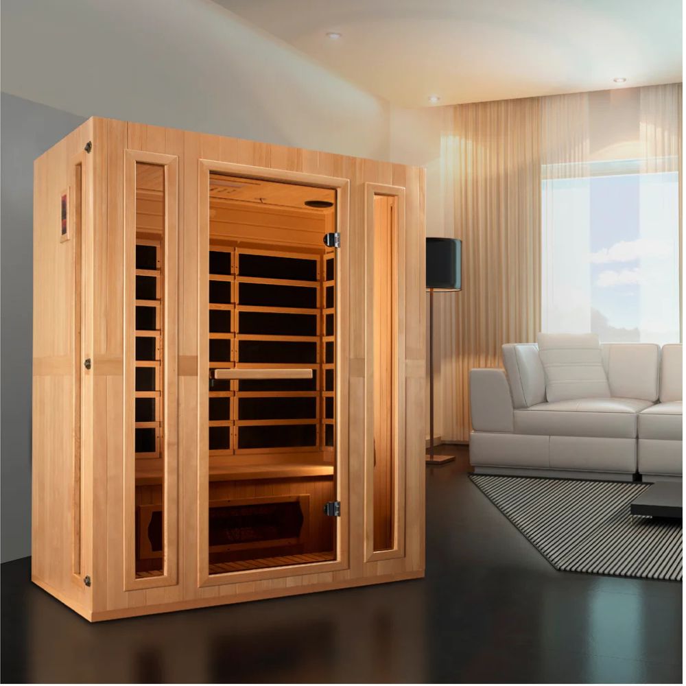 Wooden infrared sauna in a modern living room with a white sofa and large window.